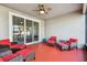 Screened-in porch with red flooring and wicker furniture at 32397 Bannack Ln, Wesley Chapel, FL 33543