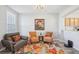 Cozy living room featuring two armchairs, a floral rug, and a kitchen pass-through at 3322 Broken Bow Dr, Land O Lakes, FL 34639