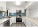 Modern kitchen with white cabinets, stainless steel appliances, and blue tile backsplash at 345 Dr Ml King Jr N St, Safety Harbor, FL 34695