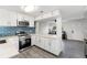 Modern kitchen with white cabinets, stainless steel appliances, and blue tile backsplash at 345 Dr Ml King Jr N St, Safety Harbor, FL 34695