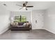 Bright living room with gray couch, ceiling fan, and gray washed wood flooring at 345 Dr Ml King Jr N St, Safety Harbor, FL 34695