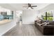 Bright living room featuring a brown sofa and wood-look flooring at 345 Dr Ml King Jr N St, Safety Harbor, FL 34695