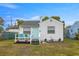 Quaint white bungalow with teal door and small deck at 3645 5Th S Ave, St Petersburg, FL 33711