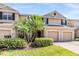 Exterior of a townhome featuring a well-manicured lawn, shrubs, and a two-car garage at 3900 Claybrook Dr, Wesley Chapel, FL 33544