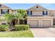 Inviting townhome with a brick driveway, two-car garage and tropical landscaping at 3900 Claybrook Dr, Wesley Chapel, FL 33544