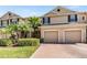 Inviting townhome with a brick driveway, two-car garage and tropical landscaping at 3900 Claybrook Dr, Wesley Chapel, FL 33544