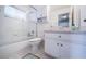 Bright bathroom featuring a shower-tub combo, white cabinets, updated fixtures, and a large mirror at 4754 Stoneview Cir, Oldsmar, FL 34677