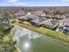 Aerial view of the house overlooking a beautiful pond and well-manicured yard at 4927 Rolling Green Dr, Wesley Chapel, FL 33543