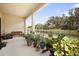 Covered back porch with a bench and many plants overlooking the backyard at 4927 Rolling Green Dr, Wesley Chapel, FL 33543