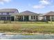 Spacious backyard with a pond view, iron fence, and covered porch at 4927 Rolling Green Dr, Wesley Chapel, FL 33543