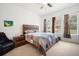 Bedroom featuring a colorful quilt, two windows, a ceiling fan, and wood furnishings at 4927 Rolling Green Dr, Wesley Chapel, FL 33543