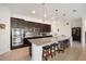 Open-concept kitchen with large island, dark cabinetry, granite countertops, and stainless steel appliances at 4927 Rolling Green Dr, Wesley Chapel, FL 33543