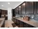 Kitchen features dark cabinets, granite countertops, and backsplash with stainless steel appliances at 4927 Rolling Green Dr, Wesley Chapel, FL 33543