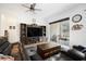Comfortable living room features a large entertainment center and sliding glass doors to the patio at 4927 Rolling Green Dr, Wesley Chapel, FL 33543