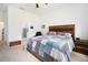 Well lit main bedroom with colorful quilt, wood furnishings and ensuite bath at 4927 Rolling Green Dr, Wesley Chapel, FL 33543