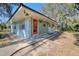 Quaint light blue home with orange door and landscaping; located on a quiet street at 6119 Beacon Point Dr, Weeki Wachee, FL 34607