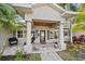 Inviting covered front porch with decorative columns, stylish seating, and lush landscaping around the entrance at 633 Poinsettia Rd, Belleair, FL 33756