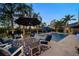 Backyard pool and patio area lit at dusk with lounge seating and a view of the well manicured property at 633 Poinsettia Rd, Belleair, FL 33756