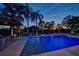 Backyard pool illuminated at dusk showcasing landscaping, patio, and lighting at 633 Poinsettia Rd, Belleair, FL 33756