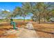 Community playground with a water fountain, mature trees, and swings under a clear blue sky at 9204 Wood Lake Blvd, Tampa, FL 33615