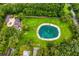 Aerial view showcasing estate with pool, pond, and surrounding greenery offering a private oasis at 1007 Lakewood Dr, Brandon, FL 33510