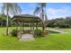 Charming gazebo with bench seating overlooking a lush lawn and serene pond at 1007 Lakewood Dr, Brandon, FL 33510