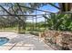 A screened-in pool with a waterfall feature and a view of mature landscaping at 1007 Lakewood Dr, Brandon, FL 33510