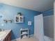 Blue bathroom showing a shower with a white shower curtain, towel racks, and a storage shelf at 10120 Post Harvest Dr, Riverview, FL 33578