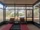 Sunroom with two lounge chairs, a small table, and views of the pond and natural landscape at 10120 Post Harvest Dr, Riverview, FL 33578