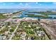 Aerial view of waterfront neighborhood with homes under construction, mature trees and nearby marina at 10455 14Th Ne St, St Petersburg, FL 33702