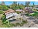 View of a home exterior featuring carports and gravel yard with a partial view of other houses at 10455 14Th Ne St, St Petersburg, FL 33702