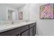 Double vanity bathroom with dark cabinets and a floral painting at 10596 Farm Hill Ave, Land O Lakes, FL 34638