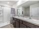 Bathroom with double vanity, shower, and striped shower curtain at 11976 Brighton Knoll Loop, Riverview, FL 33579