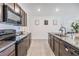 Modern kitchen with dark wood cabinets, stainless steel appliances, and granite countertops at 11976 Brighton Knoll Loop, Riverview, FL 33579