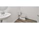 Half bathroom featuring wood-look flooring, pedestal sink, and updated fixtures at 1219 Kazaz Ct, Zephyrhills, FL 33540