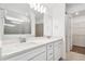 Bright bathroom features a double vanity with white cabinets, quartz countertop, and a large mirror at 1219 Kazaz Ct, Zephyrhills, FL 33540