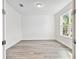 Bright, empty bedroom featuring hardwood floors, a window, white walls, and ample natural light at 1219 Kazaz Ct, Zephyrhills, FL 33540