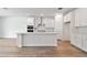 Stylish kitchen featuring white cabinets, a center island with countertop seating, and stainless steel appliances at 1219 Kazaz Ct, Zephyrhills, FL 33540