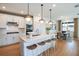 Well-lit kitchen with white cabinets, stainless steel appliances, and a breakfast bar with wooden stools at 1231 Kazaz Ct, Zephyrhills, FL 33540