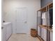 Functional laundry room with a side-by-side washer and dryer and a wooden shelving unit at 1231 Kazaz Ct, Zephyrhills, FL 33540