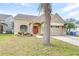 Tan one-story house with a two-car garage and landscaping at 12705 Bramfield Dr, Riverview, FL 33579