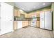 Galley kitchen with light wood cabinets and white appliances at 12705 Bramfield Dr, Riverview, FL 33579