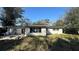 Backyard shows a home exterior with overgrown grass and plants in disrepair at 13634 Twig Ter, Largo, FL 33774