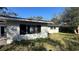 Backyard shows a home exterior with overgrown grass and plants in disrepair at 13634 Twig Ter, Largo, FL 33774