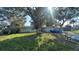 Single-story home with a mature shade tree in the front yard, adjacent to a blue car at 13634 Twig Ter, Largo, FL 33774