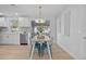 Dining area with a light wood table, teal chairs, and modern lighting at 1418 Barry St, Clearwater, FL 33756