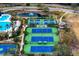 Aerial view of tennis courts, pond, and swimming pool area at 14607 Turning Leaf Ct, Tampa, FL 33626