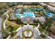 Aerial view of community pool and clubhouse surrounded by lush landscaping, tennis courts, and common areas at 14607 Turning Leaf Ct, Tampa, FL 33626