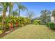 Lush backyard landscaping, mature tropical plants and grass, along with a glimpse of the pool area at 14607 Turning Leaf Ct, Tampa, FL 33626