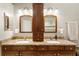 Dual vanity bathroom featuring wooden cabinets, granite countertop, and matching mirrors at 14607 Turning Leaf Ct, Tampa, FL 33626